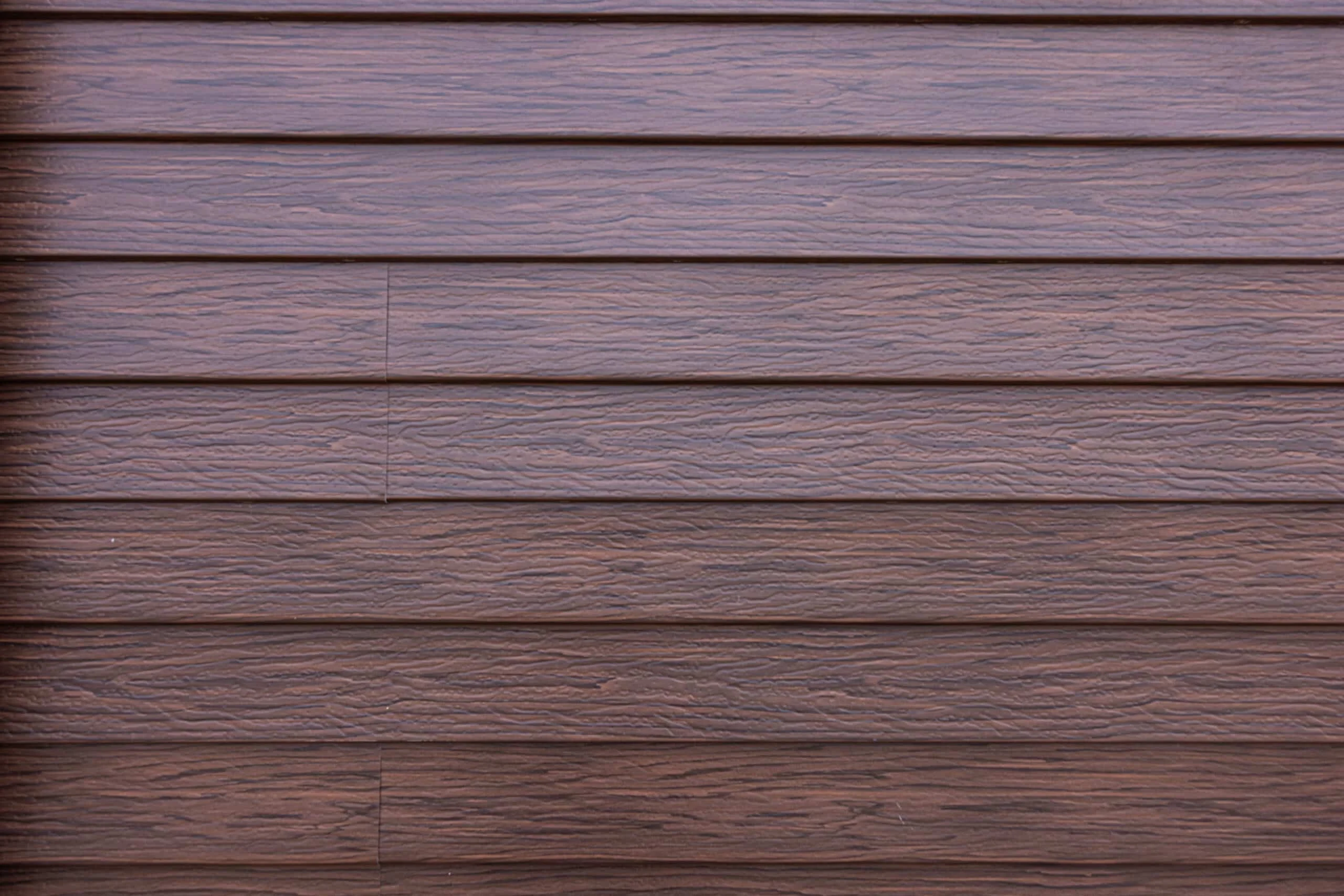 Close-up of TruLog steel lap siding wood-grain texture