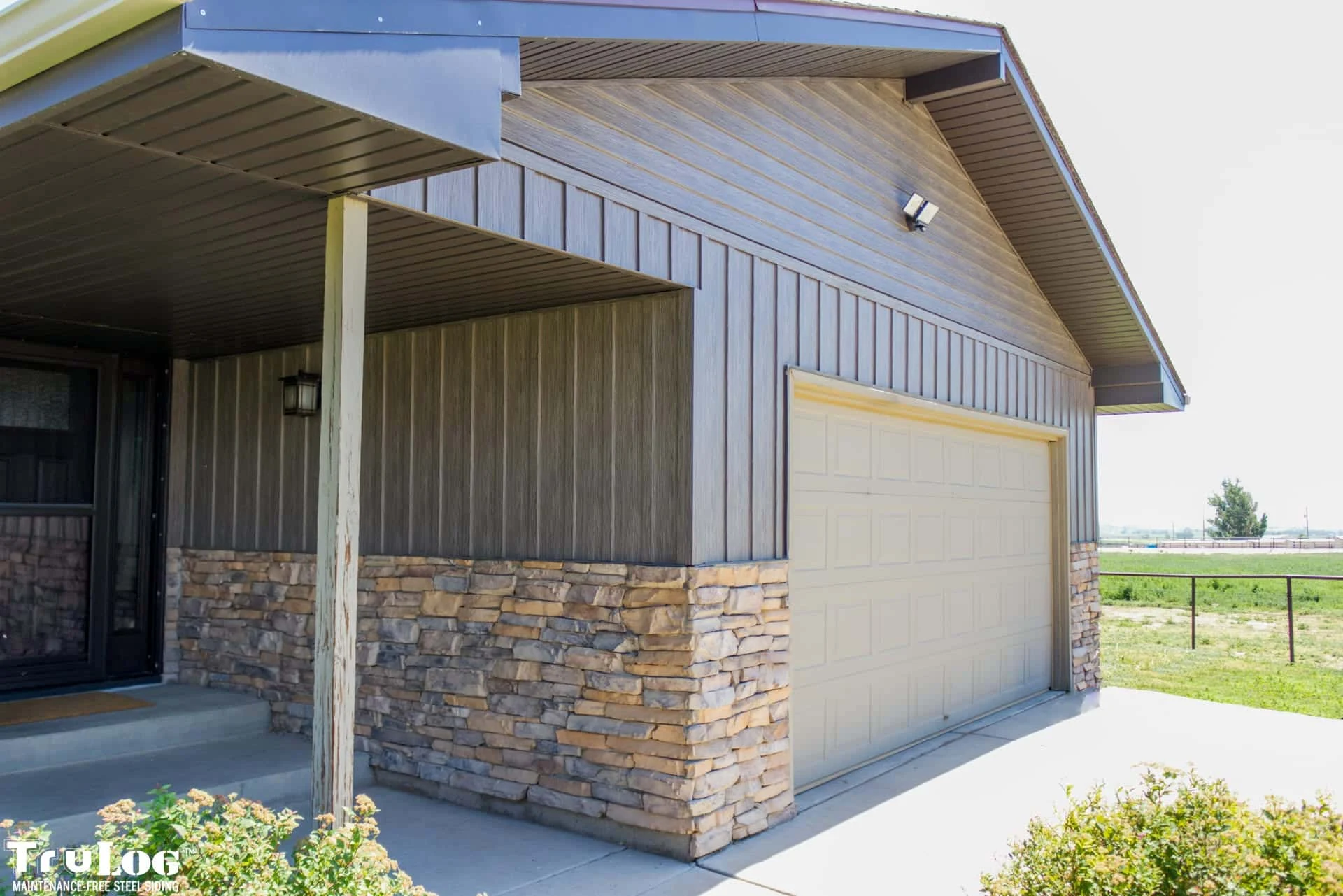 TruLog Driftwood board and batten siding on home with stone accents
